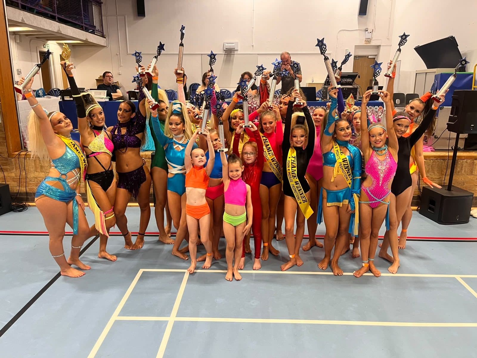 Large studio group raising trophies at Thame
