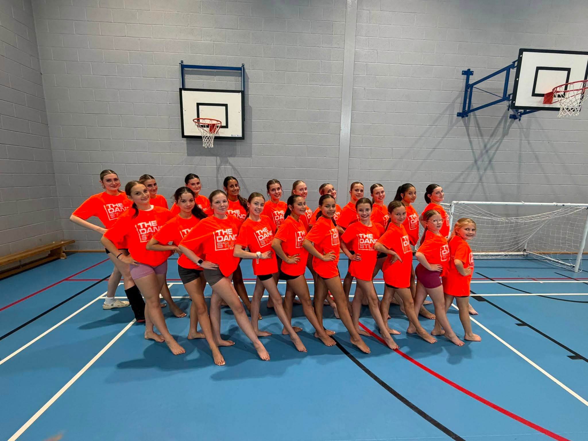 The Dance Studio group in neon orange merch